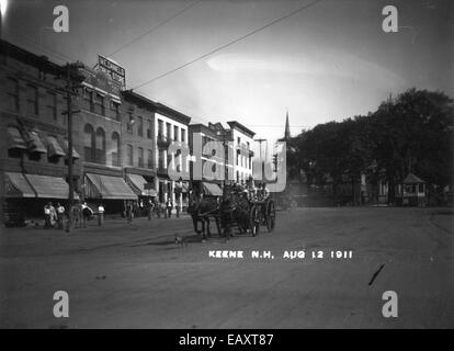 Cette image historique montre une machine de pompiers tirée par des chevaux stationnée à Central Square à Keene, New Hampshire. La photographie, attribuée à Bion Whitehouse, capture du matériel de lutte contre les incendies du passé, mettant en évidence les services d'incendie du début du XXe siècle. Banque D'Images