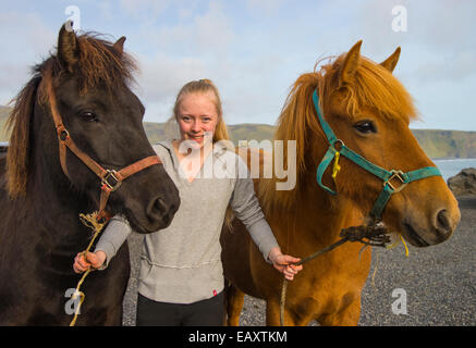 Jeune femme menant ses deux chevaux Islandais pour une randonnée. Vik, Islande, USA Banque D'Images
