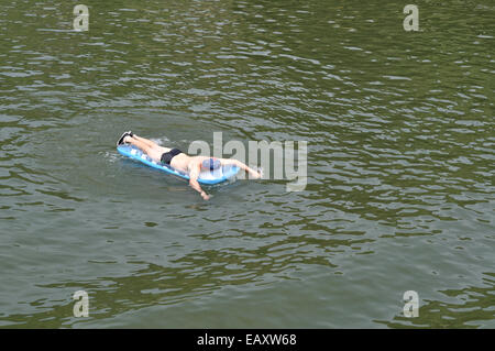 Jeune homme sur matelas flottant sur Moselle près de Cochem, Allemagne. Banque D'Images