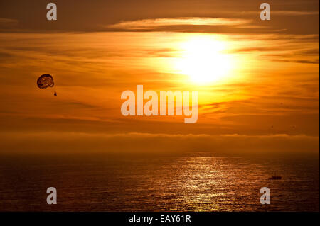 Le parapente en couple le coucher du soleil. Banque D'Images