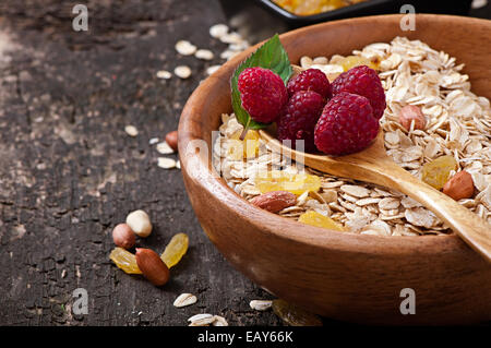 Les baies fraîches et de flocons d'avoine dans un bol en bois Banque D'Images