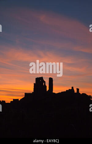 Ruines du château de Corfe silhouetted against a sunset Fiery dans le Dorset England UK Banque D'Images