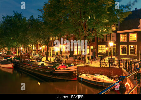 Nuit vue sur la ville d'Amsterdam canal, pont et maisons typiques, des bateaux et des vélos, en Hollande, aux Pays-Bas. Banque D'Images