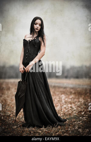 Une belle fille goth triste détient parapluie noir. Effet texture Grunge Banque D'Images