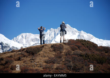 Deux trekkeurs photographie qu'il pic de Kangchenjunga à partir d'un point haut sur la Singalila ridge Banque D'Images