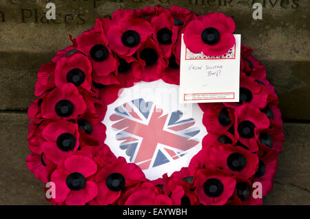 Un coquelicot solitaire couronne au nom de l'écossais d'extrême droite British National Party (BNP) placé sur un mémorial de guerre à Édimbourg. Banque D'Images