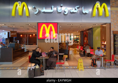 Les passagers, ayant un casse-croûte, à McDonalds,,, international, fast food, prise avant bordant leurs vols. Au départ, un salon. Bahreïn, Moyen-Orient, Banque D'Images