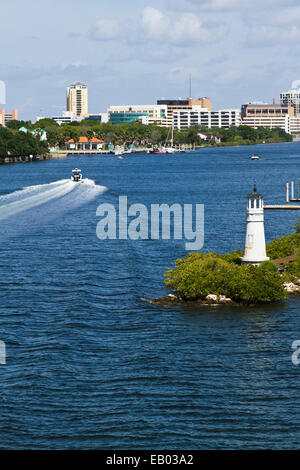 Phare miniature sur l'île de Davis, Tampa, Floride avec bateau et service sur l'eau et la ville en arrière-plan. Banque D'Images