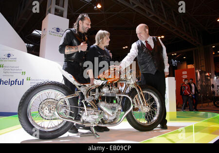 Live moto, le NEC, Birmingham, England, UK. 22 novembre 2014. Aujourd'hui est le jour de fête de St Columbanus (23 novembre). Columbanus st est le saint patron des motocyclistes et le révérend Paul Sinclair était sur place ce week-end à la Live show moto à Birmingham pour bénir le recueillies des vélos et vtt. Il est représenté en donnant une bénédiction de Vic et Lin Jefford et leur main unique construit à vélo. Crédit : Simon Hadley /Alamy Live News Banque D'Images