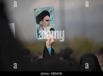 Téhéran, Iran. 23 Nov, 2014. 23 novembre 2014 - Téhéran, Iran - une femme iranienne Basiji (force paramilitaire) étudiant détient des portraits de l'Ayatollah Ali Khamenei (en bas) et à la fin de l'Ayatollah Ruhollah Khomeini, lors d'un rassemblement de soutien du programme nucléaire de l'Iran, en face de l'énergie atomique de l'Iran à Téhéran, bâtiment de l'Organisation. Morteza Nikoubazl/ZUMAPRESS : Morteza Nikoubazl Crédit/ZUMA/Alamy Fil Live News Banque D'Images