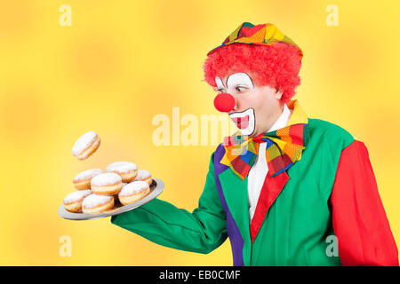 Clown avec pancake sur plateau sur fond jaune Banque D'Images