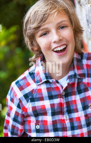 Young happy laughing boy à l'extérieur portant une chemise à carreaux vérifié Banque D'Images