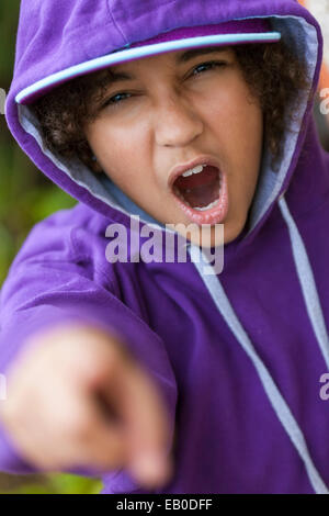 Young African American girl enfant femelle portant des sweat à capuche & baseball cap criant et en pointant à l'appareil photo Banque D'Images