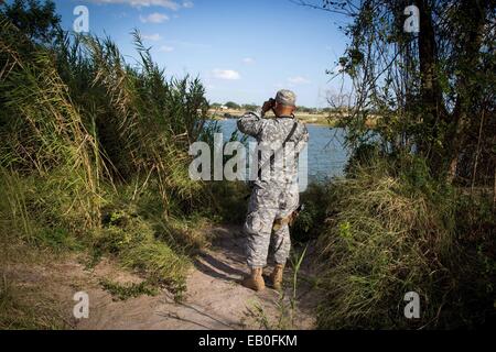 Un soldat de la Garde nationale du Texas observe une section de la rivière Rio Grande le long de la frontière entre le Texas et à l'appui de l'opération de sécurité solide pour aider à garder la frontière le 11 septembre, 2014 à McAllen, Texas. Banque D'Images