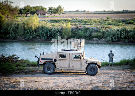 Un soldat de la Garde nationale du Texas observe une section de la rivière Rio Grande le long de la frontière entre le Texas et à l'appui de l'opération de sécurité solide pour aider à garder la frontière le 11 septembre, 2014 à McAllen, Texas. Banque D'Images