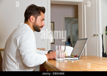 Jeune homme avec portable dans le home office Banque D'Images