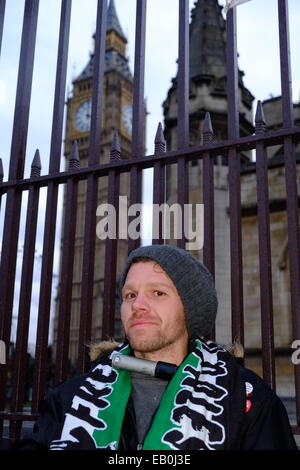 Londres, Royaume-Uni. 23 novembre 2014. Les manifestants occupent l'extérieur du Parlement continuent leur manifestation avec un homme qui se présente comme l'opération "Iron Man" s'attacher à la grille avec un D-lock Crédit : Rachel Megawhat/Alamy Live News Banque D'Images