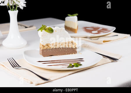 Tranches de gâteau du four Gourmet sur plaque blanche, servir sur le tableau blanc avec cadre formel. Banque D'Images