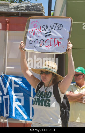 Jeune femme nous tend un panneau disant 'MONSANTO  = ÉCOCIDE' à un OGM de protestation Banque D'Images