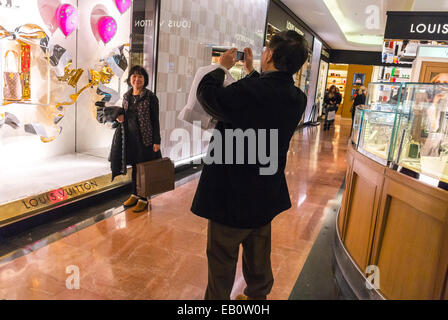 Paris, France, touristes chinois, acheteurs prenant des photos, Shopping, grand magasin français, Galeries Lafayette, vitrine de luxe Louis Vuitton, présentoir, intérieur haute couture, shopping de marque internationale Banque D'Images