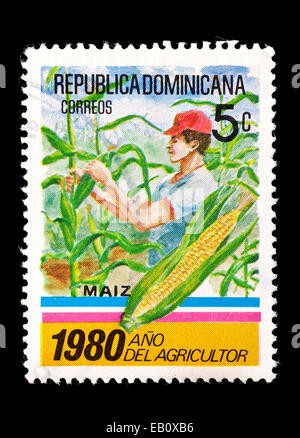 Timbre-poste de Dominique représentant un agriculteur vérifie son maïs. Banque D'Images