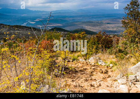Voir l'automne de la Croix (Krizevac) Mountain à Medjugorje en Bosnie Erzegovina ed : arbres brunâtre, mauvaises herbes vertes, orange et jaune des feuilles et rochers gris Banque D'Images