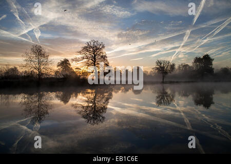 Pays Langley Park à Slough, Berkshire, Royaume-Uni. 24 novembre, 2014. Les traînées d'avions plus de Heathrow sont pris dans l'aube soleil. Crédit : Kevin Day/Alamy Live News Banque D'Images