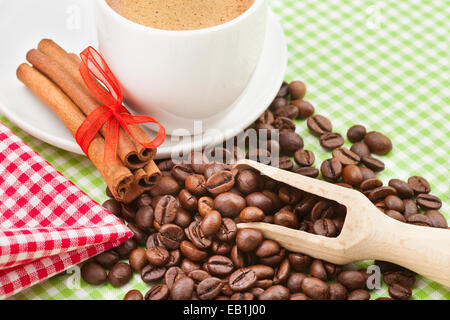 Tasse à café, des bâtons de cannelle et les grains de café sur la table de cuisine Banque D'Images