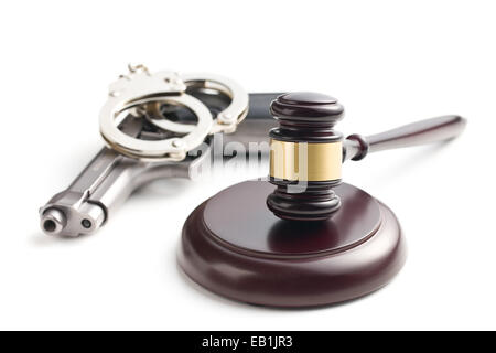 Judge's gavel et revolver avec des menottes sur fond blanc Banque D'Images