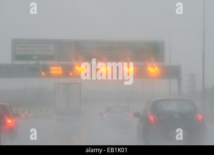 Les limites de vitesse et les panneaux d'avertissement de la file d'allumer pendant une pluie battante sur l'autoroute M2 au Royaume-Uni Banque D'Images