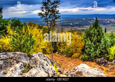 Voir l'automne de la Croix (Krizevac) Mountain à Medjugorje en Bosnie Erzegovina ed : arbres brunâtre, mauvaises herbes vertes, orange et jaune des feuilles et rochers gris Banque D'Images