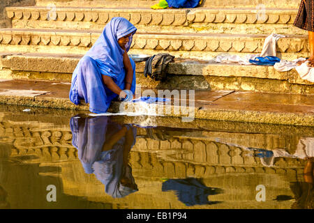 Femme Laver les vêtements dans le fleuve saint Ganges, Varanasi, Uttar Pradesh, Inde Banque D'Images