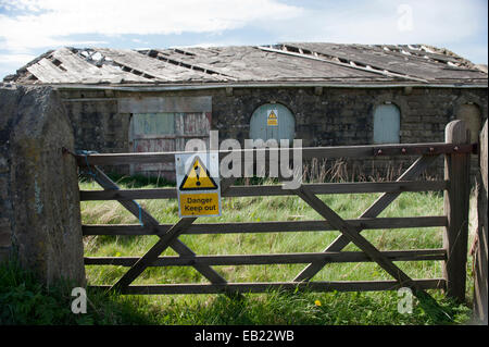 Garder hors des signes sur un derlict bâtiment de ferme dans un dangereux état de réparation. Le Lancashire, Royaume-Uni Banque D'Images