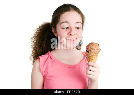 Fille de latina adolescents avec des cheveux bouclés et rousseur tenant un cornet de crème glacée au chocolat délicieux et convertible dans ant Banque D'Images