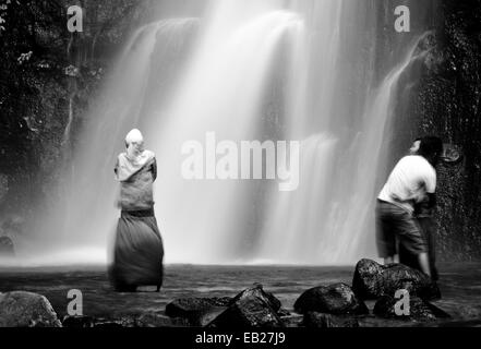 Couple embrasse à ce noir et blanc image à contraste élevé de l'amour dans une brume à une cascade tropicale surréaliste créé à l'aide de photos à longue exposition Banque D'Images