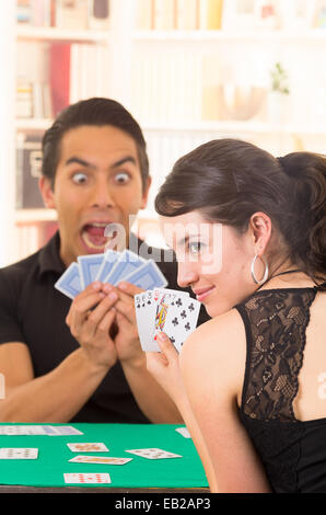 Young couple playing cards cuarenta Banque D'Images