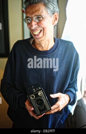 Photographe cubain Julio Bello, tenant sa première caméra, une vieille caméra Brownie à son domicile de La Havane. Banque D'Images