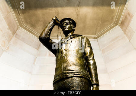 Une statue en bronze d'un marin de la Première Guerre mondiale en uniforme au sujet de souffler son Bosun's pipe, un type de sifflet. Banque D'Images