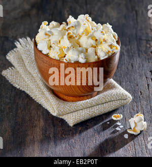 Dans un bol de pop-corn frais sur la vieille table en bois, isolée Banque D'Images