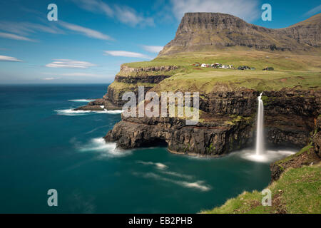Cascade sur les falaises près d'un village, de Gásadalur, Pigalle, îles Féroé, Danemark Banque D'Images