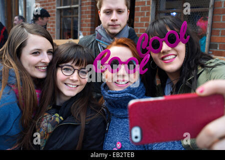 Les adolescents en tenant vos autoportraits lui-même avec des lunettes fashion rose Cool. Musique, danse, costumes et parti à Binche Carnaval. Ancienne Banque D'Images