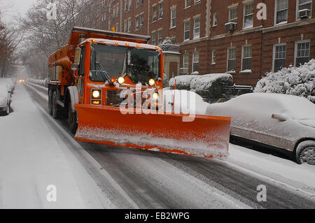 Un chasse-neige passe des voitures en stationnement dans la ville de New York pendant un blizzard. Banque D'Images