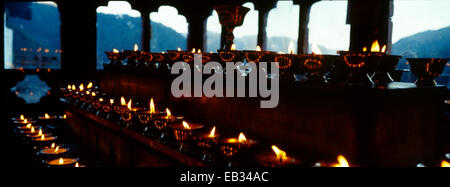 Des mesures à plusieurs niveaux dans un monastère bouddhiste de l'himalaya bordé de rangées de lampes à beurre pour la prière et l'adoration. Banque D'Images