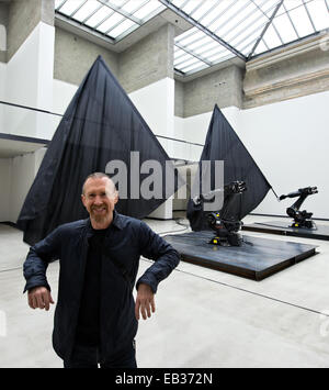 Dresde, Allemagne. 25Th Nov, 2014. Danseuse, chorégraphe et artiste William Forsythe se trouve en face de deux robots industriels en agitant des drapeaux noir géant dans l'exposition 'William Forsythe Drapeaux noirs' dans le White Cube à la Kunsthalle dans le Lipsiusbau à Dresde, Allemagne, 25 novembre 2014. L'exposition dans la nouvelle Galerie Masters se déroule en collaboration avec l'American danseur, chorégraphe et artiste Forsythe et 'The Forsythe Company." c'est à l'affiche du 27 novembre 2014 jusqu'au 11 janvier 2015. Dpa : Crédit photo alliance/Alamy Live News Banque D'Images