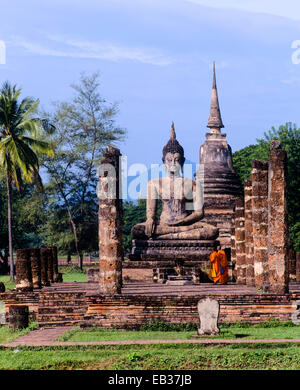 Deux moines debout devant le Bouddha assis au temple Wat Mahathat, ruines, chedi, le parc historique de Sukhothai, Thaïlande Banque D'Images