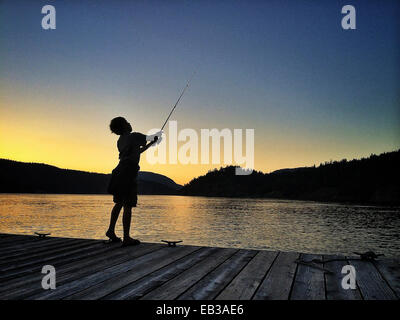 Young boy fishing on dock at Lake Banque D'Images