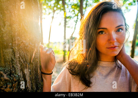 Caucasian woman leaning against tree in park Banque D'Images