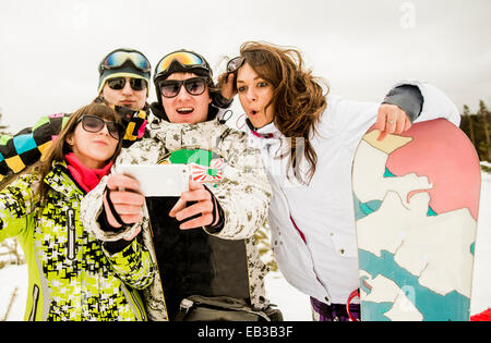 Caucasian friends with snowboard selfies en tenant Banque D'Images