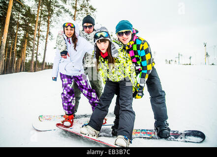 Portrait des couples snowboard posing on snowy slope Banque D'Images