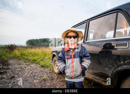 Caucasian boy standing près de location in rural field Banque D'Images